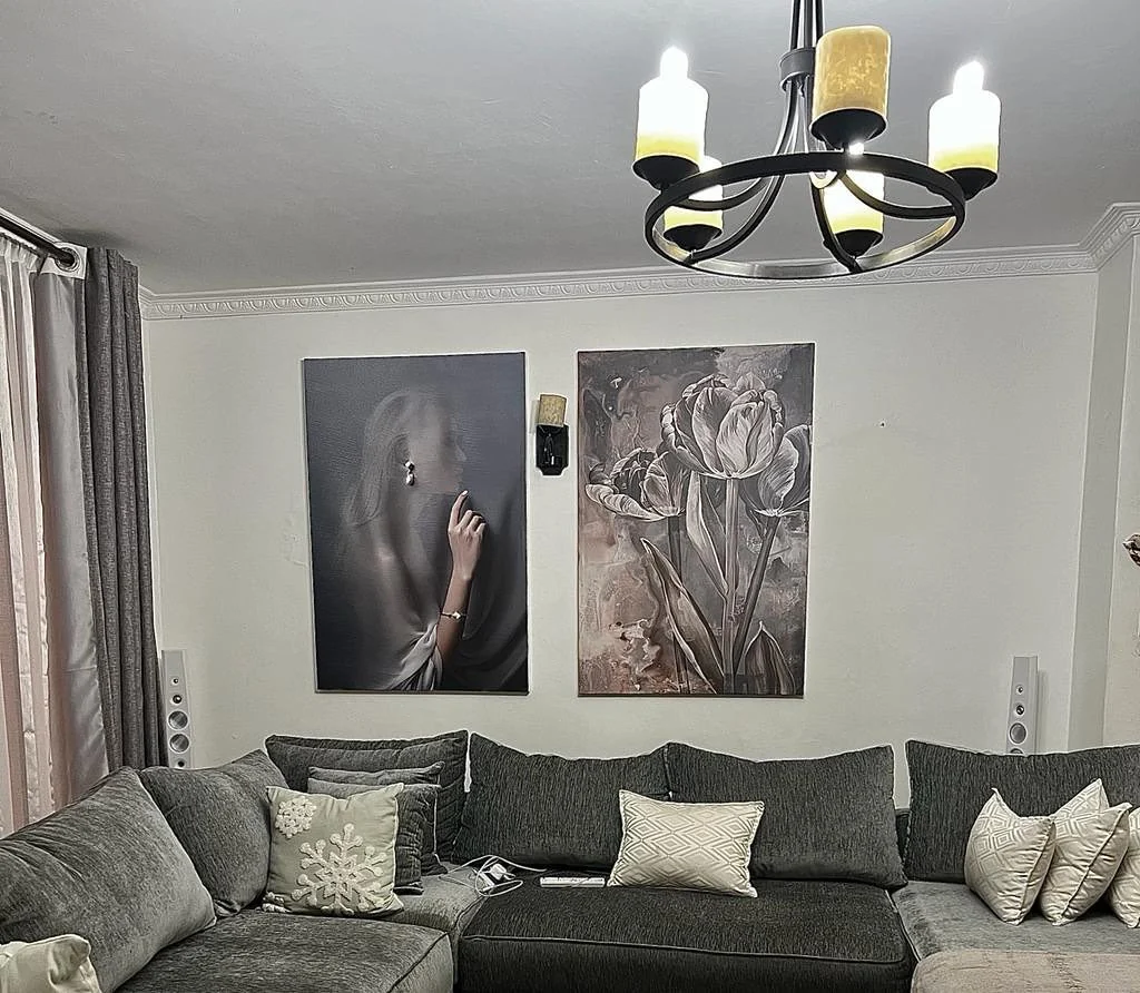 Two monochrome animal portraits above a grey sofa