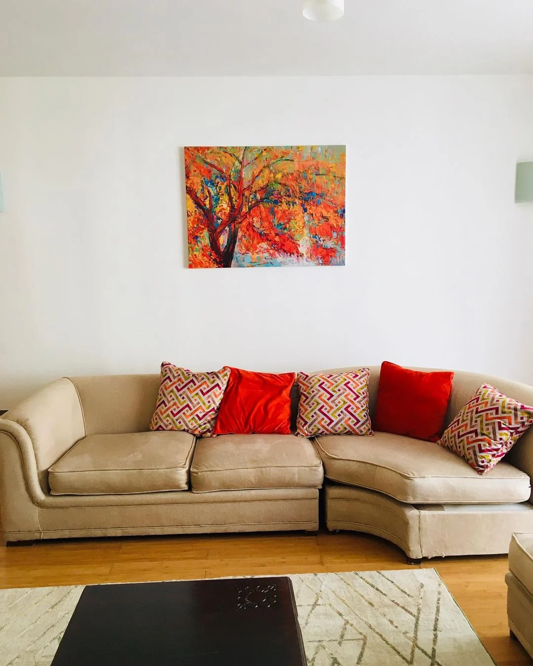 Abstract canvas above a cream sofa with red cushions