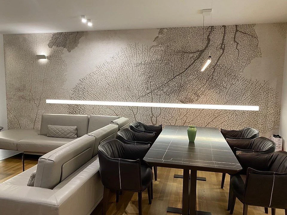 Textured leaf-pattern wallpaper behind a corner sofa